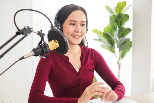 Beautiful asian young woman radio host working in headphones, microphone while talk, conversation and recording podcast, live on social media.Technology of on-air online in broadcasting at studio. photo