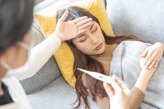 Sick, influenza asian young woman, girl headache have high fever, flu check thermometer measure body temperature, feel illness while lying on sofa, couch at home. Health care, infection of covid-19. photo