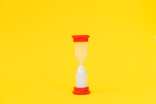 Hourglass from a board game on a yellow background photo
