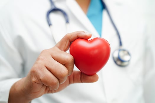 Asian woman doctor holding red heart for health in hospital. photo