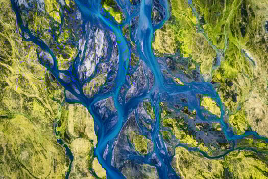 Abstract blue glacier rivers pattern flowing through volcanic moss field in Icelandic highlands on summer photo