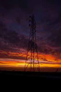 High voltage power line tower with beautiful sky at sunset, stock photo