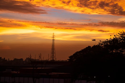 Sunset over the city, silhouette of a high voltage transmission tower photo
