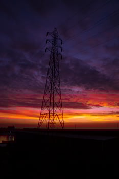High voltage power line tower with beautiful sky at sunset, stock photo