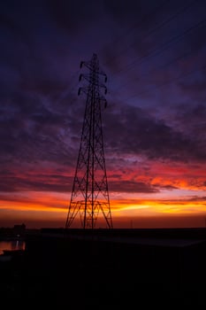 High voltage power line tower with beautiful sky at sunset, stock photo