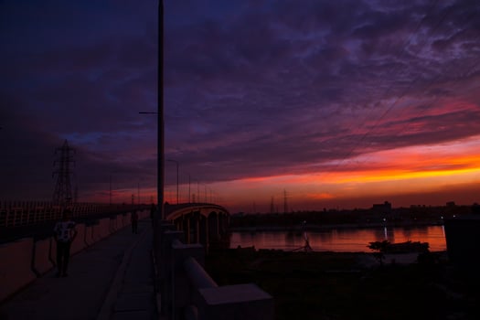 Sunset over the river in the city. The bridge crosses the river photo