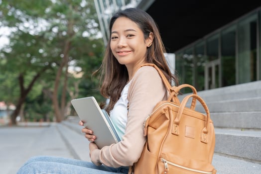 Beautiful student asian woman with backpack and books outdoor. Smile girl happy carrying a lot of book in college campus. Portrait female on international Asia University. Education, study, schoo photo