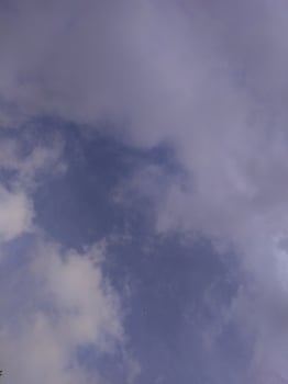 White clouds in the blue sky. Beautiful bright blue background. Light cloudy, good weather. Curly clouds on a sunny day. photo