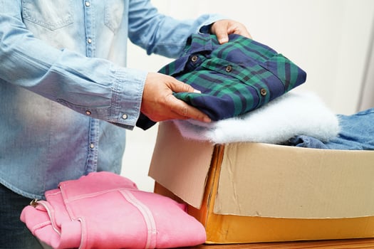 Clothes donations in cardboard box for volunteer. photo
