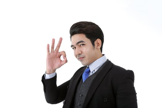 Southeast Asian young office business man wearing suit ok finger sing happy expression on white studio background photo