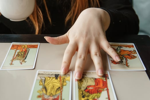 TVER, RUSSIA - FEBRUARY 11, 2023. Tarot cards, Tarot card divination, esoteric background. A woman makes a layout on the cards at the table. Divination, predictions on tarot cards. photo