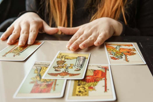 TVER, RUSSIA - FEBRUARY 11, 2023. Tarot cards, Tarot card divination, esoteric background. A woman makes a layout on the cards at the table. Divination, predictions on tarot cards. photo