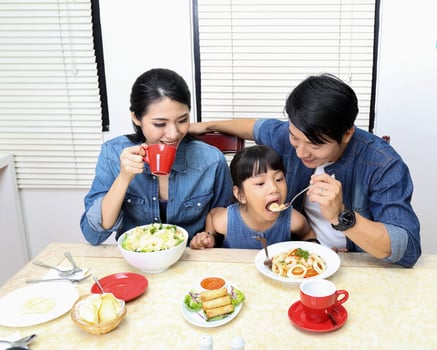 South east asian yong family daughter child parent father mother at dining table eating food lunch photo