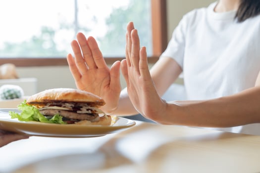 Beauty slim female body confuse hamburger. Woman in restaurant achieves weight loss goal for healthy life, crazy about thinness, thin waist, nutritionist. Diet, body shape. photo