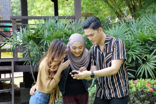 Young Asian Malay man woman outdoor green park walk talk discuss mingle photo