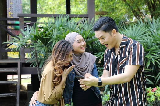 Young Asian Malay man woman outdoor green park walk talk discuss mingle photo