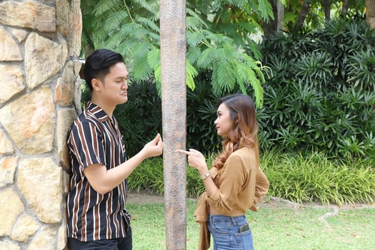 Young Asian Malay man woman outdoor green park walk talk discuss mingle under umbrella photo