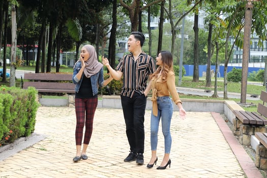 Young Asian Malay man woman outdoor green park walk talk discuss mingle photo