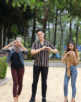 Young Asian Malay man woman outdoor green park walk talk discuss mingle sign show photo