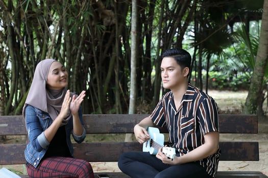 Young Asian Malay man woman outdoor green park walk talk discuss mingle photo