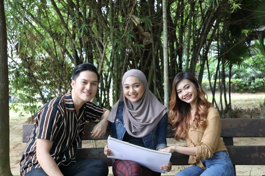 Young Asian Malay man woman outdoor green park walk talk discuss mingle photo