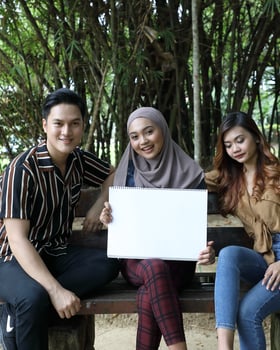 Young Asian Malay man woman outdoor green park walk talk discuss mingle photo