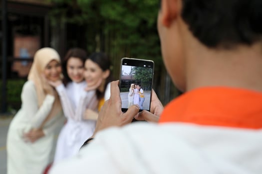 Group young asian chinese malay man woman wearing headscarf outdoor friend student colleague happy take photo portrait by hand phone smart phone screen