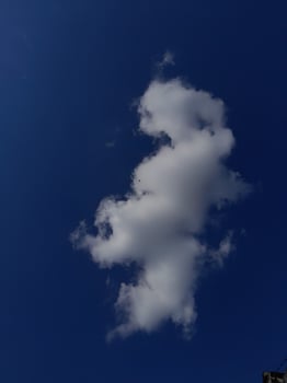 White clouds in the blue sky. Beautiful bright blue background. Light cloudy, good weather. Curly clouds on a sunny day. photo