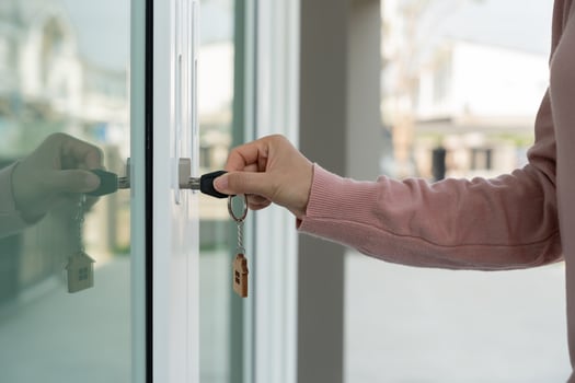 Landlord key for unlocking house is plugged into the door. Second hand house for rent and sale. keychain is blowing in the wind. mortgage for new home, buy, sell, renovate, investment, owner, estate photo