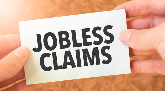 JOBLESS CLAIMS word inscription on white card paper sheet in hands of a businessman. recap concept. red and white paper photo