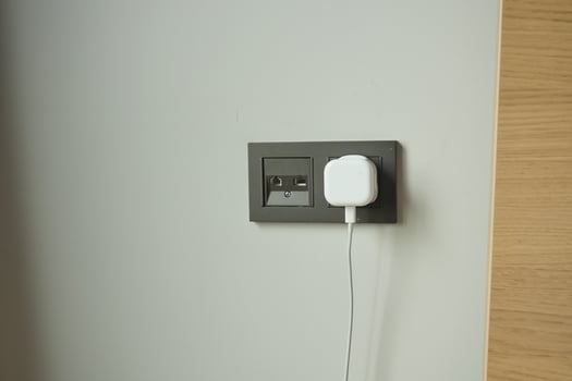 white color power cord cable plugged into wall photo