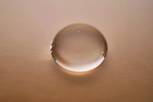 A juicy drop of gel on a beige background. photo
