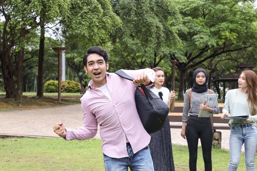 Young asian malay chinese man woman outdoor park walk stand study talk discuss point laptop file book backpack joy victory photo