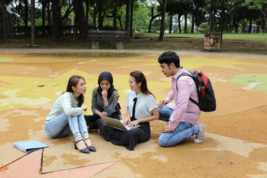 Young asian malay chinese man woman outdoor park sit on ground study talk discuss point laptop file book backpack mingle fun meet photo