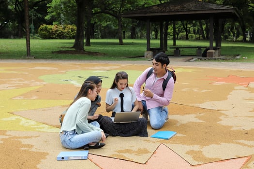 Young asian malay chinese man woman outdoor park sit on ground study talk discuss point laptop file book backpack mingle fun meet photo