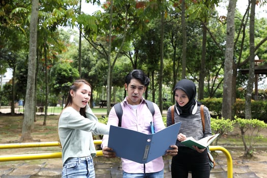 Young asian malay chinese man woman outdoor park walk stand study talk discuss point laptop file book backpack mingle photo