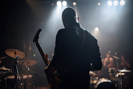 musician playing electric guitar on stage with stage lights and drum kit, A guitarist full rear view playing the guitar, photo