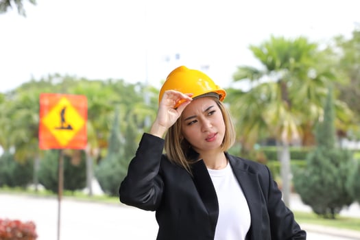 woman Malay Chinese worker engineer management hard safety hat helmet at construction site hand on hat thinking worried photo