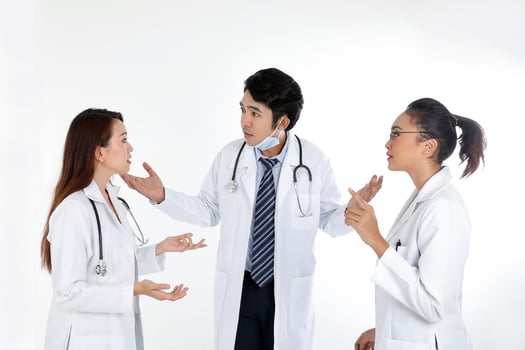 Asian Malay Chinese male female three doctors talking discussing serious on white background photo