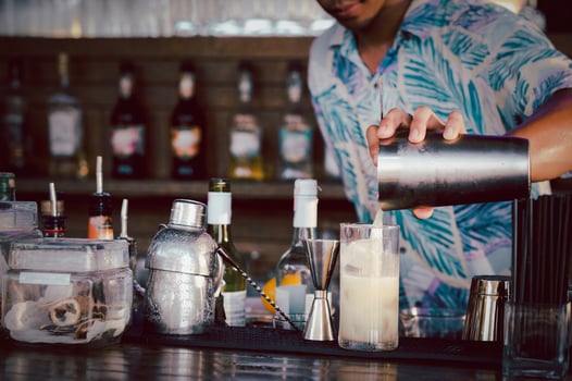Bartender pouring a cocktail from a shaker into the glass photo