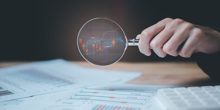 statistical analyst using calculator to calculate and read reports, graphs and charts, business statistics ,Analysis and improvement of corporate strategy ,manage financial ,marketing documents photo