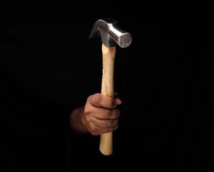 Asian male dark skinned single hand fist finger on black background holding using hammer photo