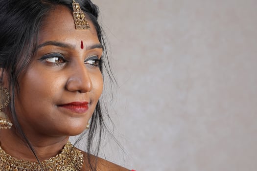 Indian woman wearing red orange traditional royal saree jewellery choker set necklace jhumka earring maang tikka waist chain stand pose look see smile mood expression at old rustic room background photo