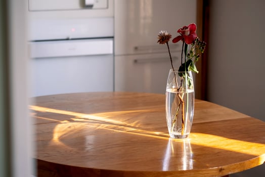 A bouquet in a transparent vase on a wooden table in the rays of the sun. photo