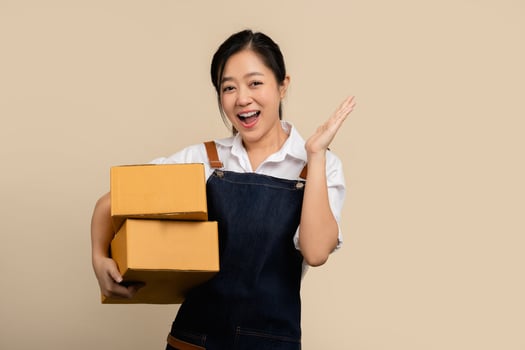 Happy cute asian woman smiling wearing apron and holding package online marketing and delivery Start a small business at home, Delivery shipping service concept. photo