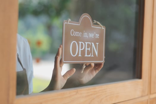 Welcome. Open. barista, waitress woman turning open sign board on glass door in modern cafe coffee shop ready to service, cafe restaurant, retail store, small business owner, food and drink concept photo