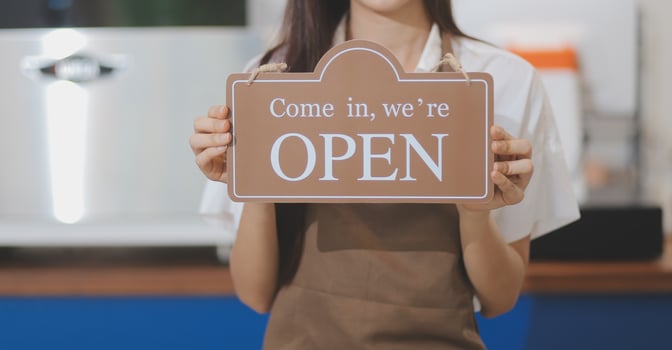 Welcome. Open. barista, waitress woman turning open sign board on glass door in modern cafe coffee shop ready to service, cafe restaurant, retail store, small business owner, food and drink concept photo