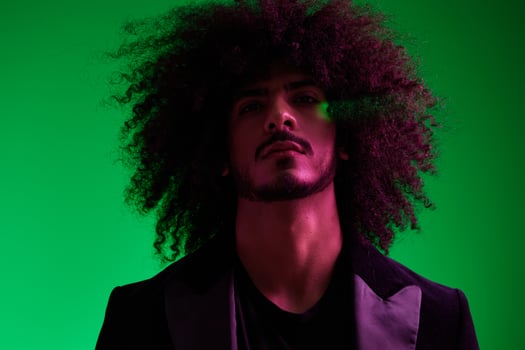 Portrait of a stylish man in a jacket on a green background multinational, color light, trend. photo