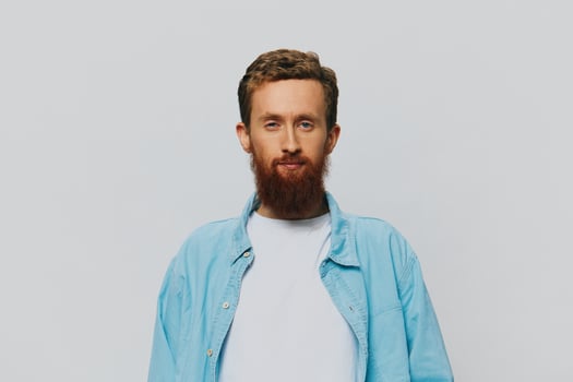 Male hipster portrait smile on gray background in blue shirt and white t-shirt, portrait of a man with a beard photo