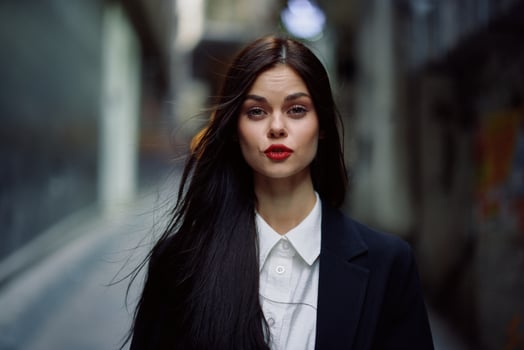 Fashion woman dramatic portrait tourist in stylish clothes in jacket and red beret walking down narrow city street flying hair, travel, French style, cinematic color, retro vintage style. photo